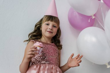 kirli burun cupcake pembe balonlar demet yakınındaki yeme ile Doğum günü çocuk düşük açılı görünüş 