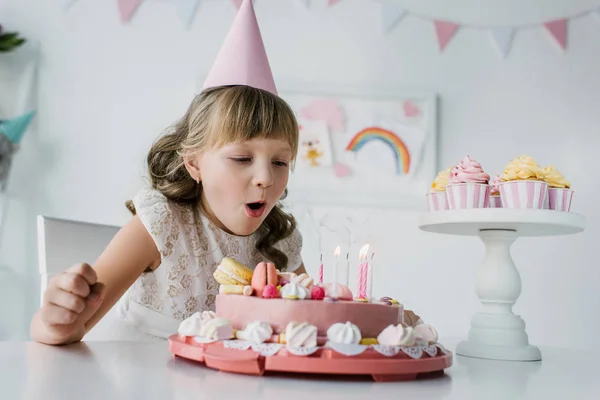 Adorable Niño Cono Soplando Velas Pastel Cumpleaños Mesa — Foto de Stock