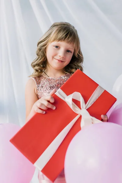 Чарівна Усміхнена Дитина Тримає Подарункову Коробку Загорнуту Стрічкою — Безкоштовне стокове фото