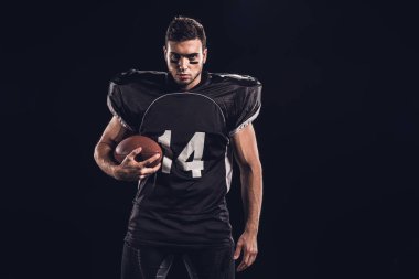 siyah izole kamera bakarak topu ile genç emin Amerikan futbolu oyuncusu