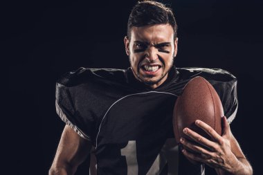yakın çekim portre siyah izole kamera bakarak topu ile kızgın Amerikan futbolu oyuncusu