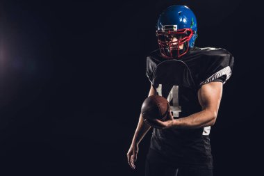 siyah izole kamera bakarak topu ile yakışıklı Amerikan futbolu oyuncusu