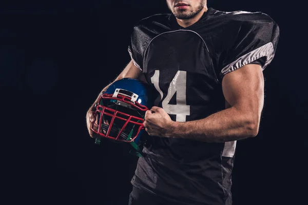 黒に分離されたヘルメットを保持している筋肉のアメリカン フットボール選手のクロップ撮影 — ストック写真
