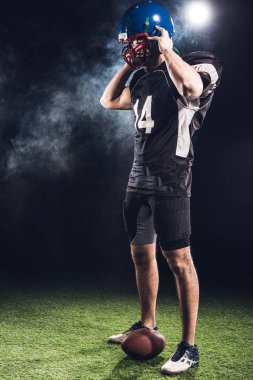 siyah kask kapalı alarak genç Amerikan futbolu oyuncusu