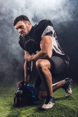 diz siyah kask ayakta ile kızgın genç Amerikan futbolu oyuncusu