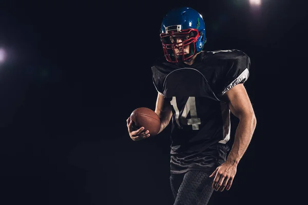 Siyah Izole Topu Ile Donatılmış Amerikan Futbolu Oyuncusu — Stok fotoğraf