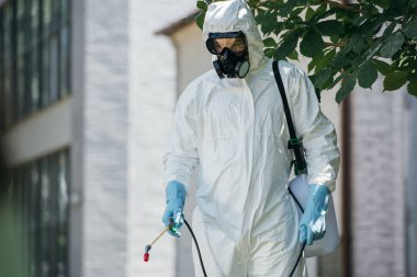 pest control worker spraying pesticides on street with sprayer   clipart