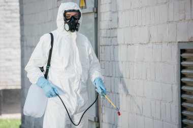 haşere kontrol işçi spreyi bina duvar üzerinde böcek ilacı püskürtme solunum