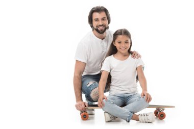 gülümseyen baba küçük kızı beyaz izole kaykay üzerinde yakınındaki