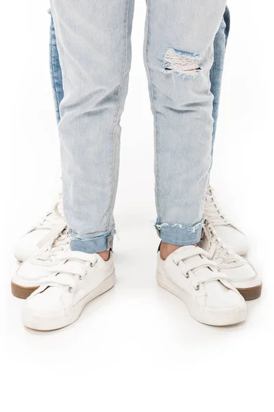 partial view of family in jeans and white footwear isolated on white