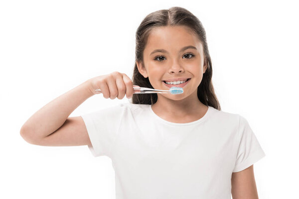 portrait of smiling kid with toothbrush looking at camera isolated on white