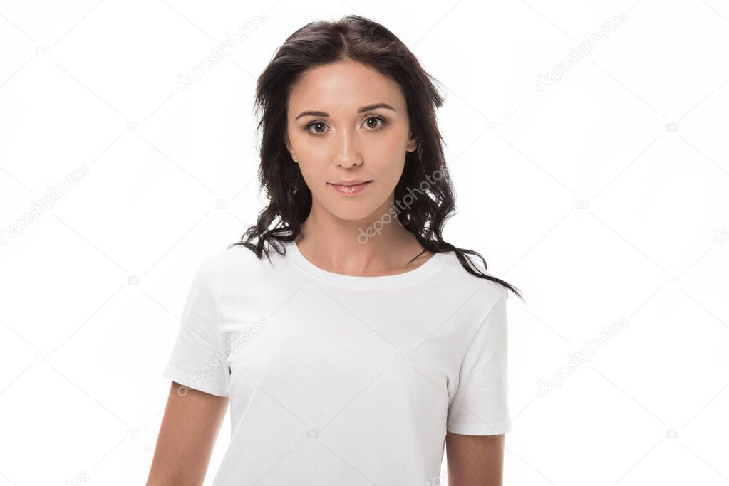 portrait of pensive young woman in white shirt looking at camera isolated on white