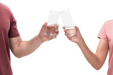 partial view of couple clinking glasses of water isolated on white clipart