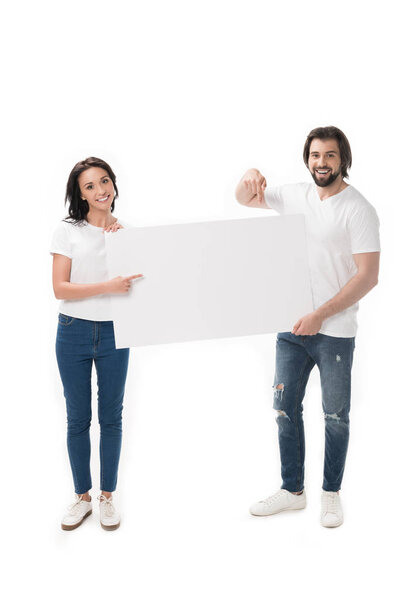 smiling couple pointing at blank banner isolated on white