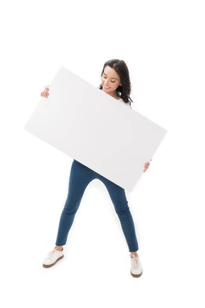 smiling woman looking at blank banner in hands isolated on white