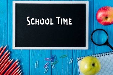 okul zamanı, elma ve kırtasiye mavi ahşap arka plan üzerinde yazı ile yazı tahtası üstten görünüm 