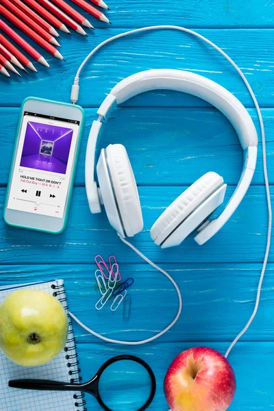 スクリーン ヘッドフォン リンゴ 青い木製の背景にひな形アップル音楽アプリケーションとスマート フォンのトップ ビュー — ストック写真