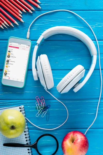 スクリーン ヘッドフォン リンゴ 青い木製の背景にひな形アップル音楽アプリケーションとスマート フォンのトップ ビュー — ストック写真