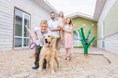 parents and children standing with adopted labrador at animals shelter clipart