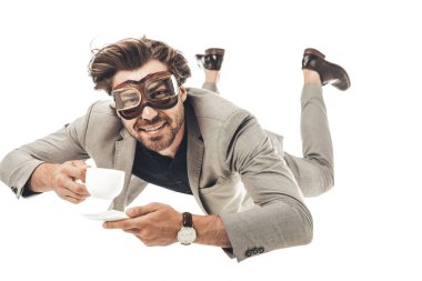 handsome young businessman in vintage aviation goggles falling with cup of coffee isolated on white clipart