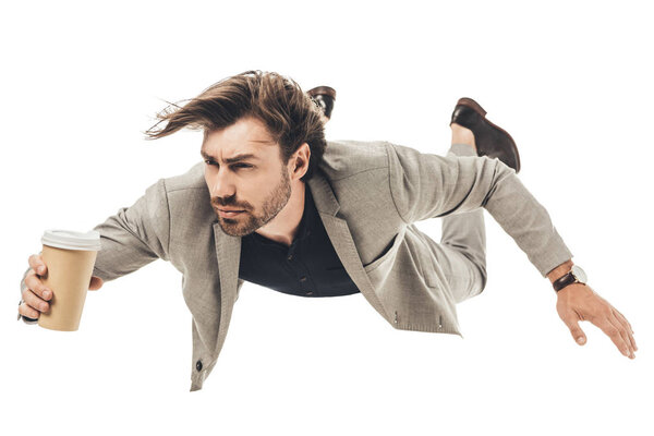 Красивый молодой бизнесмен в костюме падает изолированным на белом
