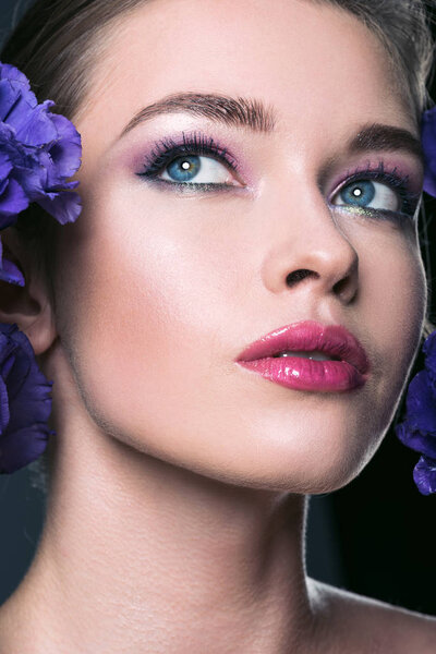 крупным планом портрет красивой молодой женщины с модным макияжем и цветами эустомы
