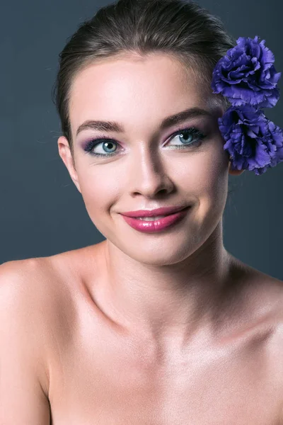 Close-up portrait of smiling young woman with eustoma flowers behind ear looking away isolated on grey — Stock Image Close Portrait Smiling Young Woman Eustoma Flowers Ear Looking Away Royalty Free Stock Photos