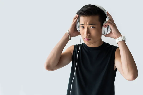 严肃的亚洲运动员戴上耳机在灰色背景下被隔离 — 图库照片