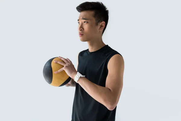 スマートウォッチは 灰色の背景に分離された薬のボールを保持するいると自信を持ってアジア スポーツマン  — 無料ストックフォト