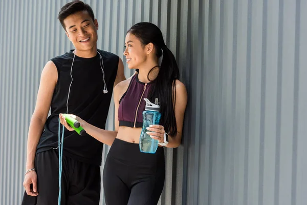 Sonriente Asiático Sportswoman Celebración Botella Agua Dando Salto Cuerda Joven — Foto de Stock