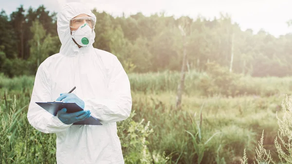 Male Scientist Protective Mask Googles Suit Looking Away Writing Clipboard — Stock Photo, Image