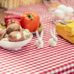 Primo piano di telefono vintage con varie verdure e coniglietti di porcellana sul tavolo
