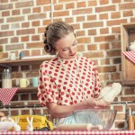 Hermosa ama de casa adulta con masa para hornear en la cocina