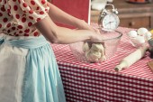 Schnappschuss von Hausfrau bei Teigzubereitung in Glasschüssel in Küche