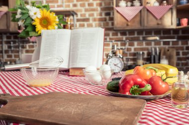 farklı pişmemiş ürünler ve mutfak masasında pişirme tarifi kitabı