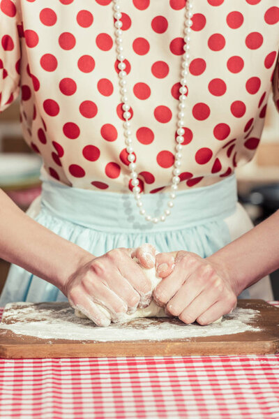 cropped shot of woman kneading dough with hands