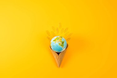top view of earth globe in waffle cone with paper clips on yellow clipart