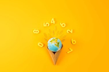 top view of earth globe in waffle cone surrounded with digits on yellow clipart