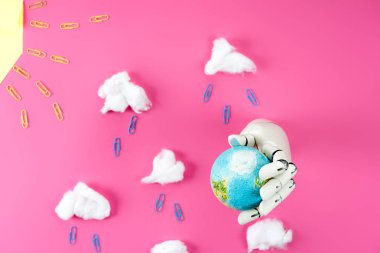 ataç ve pamuk pembe üzerinde dünya küre tutan robot el ile düzenlenmiş yağmur kompozisyon üstten görünüm