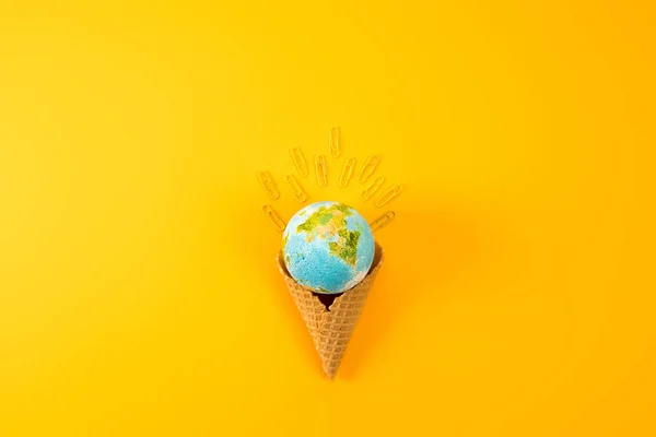 在黄色纸夹子的华夫饼锥中地球地球仪的顶部视图 — 图库照片