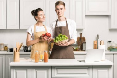 salata yemek ve mutfak sebze ile ayakta genç çift
