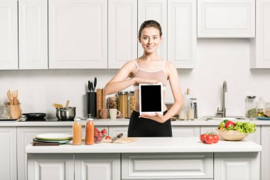 Spor sutyen holding tablet çekici kız mutfakta boş ekran ile