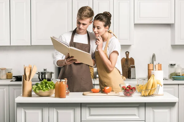 Joven Pareja Cocina Ensalada Mirando Libro Cocina Cocina —  Fotos de Stock