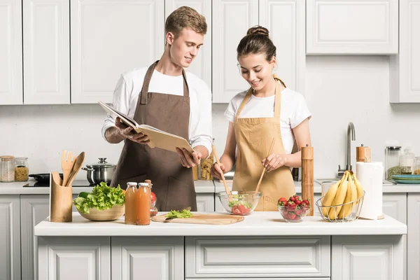 Genç Çift Yemek Tarifi Kitabı Mutfak Ile Salata — Stok fotoğraf