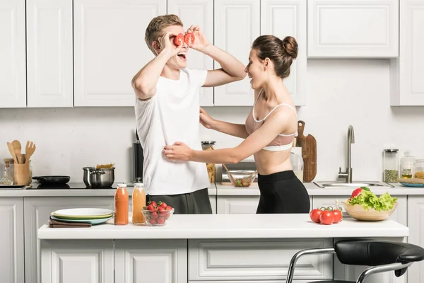 キッチンでパスタを調理しながら楽しいを持っている若いカップル — ストック写真