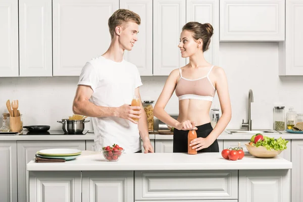 若いカップルはお互いを見て キッチンに健康ジュース — ストック写真