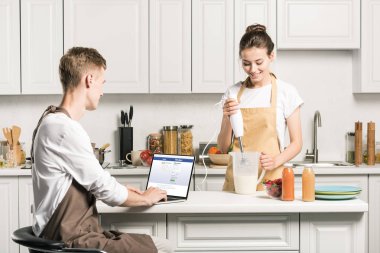 pişirme kız ve erkek arkadaşı dizüstü yüklü facebook sayfası mutfak ile kullanma