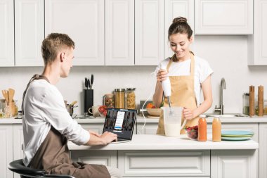 pişirme kız ve erkek arkadaşı dizüstü yüklü LinkedIn sayfa mutfak ile kullanma