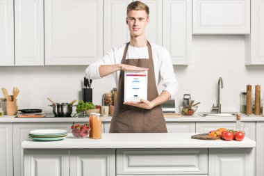 yakışıklı adamla dolu instagram sayfa mutfak önlük gösteren tablet