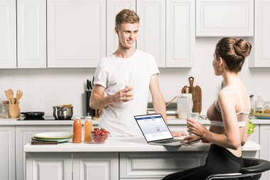 dizüstü yüklü facebook sayfası ile kullanma ve erkek mutfakta bakarak kız